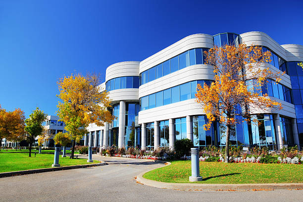 edificio corporativo en otoño colorido - bloque de oficinas fotografías e imágenes de stock