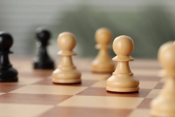 istock Wooden pawns on chess board, closeup. Space for text 1644792997