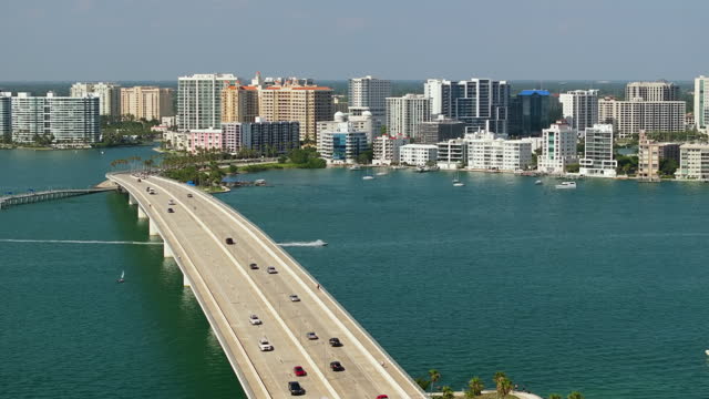 Development of housing and transportation in the US. Above view of Sarasota city, Florida with waterfront office highrise buildings and John Ringling Causeway leading from downtown to St. Armands Key