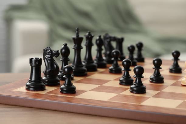 istock Chess board with black pieces on wooden table, closeup 1644793552