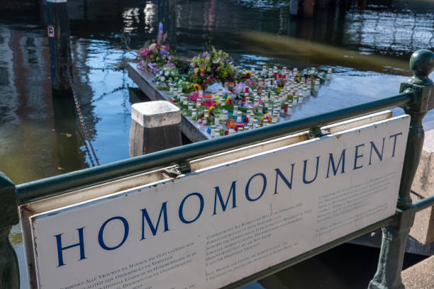 The Homomonument memorial in Amsterdam Amsterdam, The Netherlands - 6 September 2022: The Homomonument memorial commemorates all gay men and lesbians who have been persecuted pink memorial candle with flowers stock pictures, royalty-free photos & images
