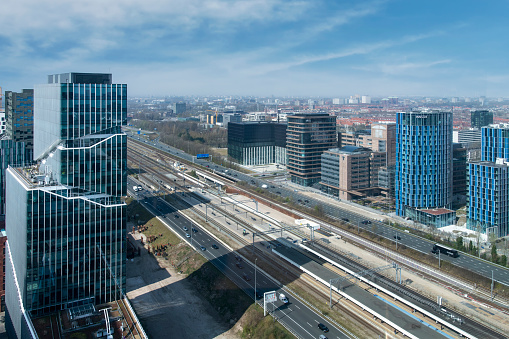 Amsterdam, The Netherlands-April 2022; High angle view of highway and train tracks and public transit exchange on Zuidas financial district and iconic building Vinoly at the Gustav Mahler Square