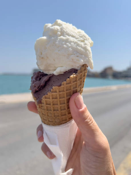 istock hand holds ice cream cone over sea in a sunny day 1644846959