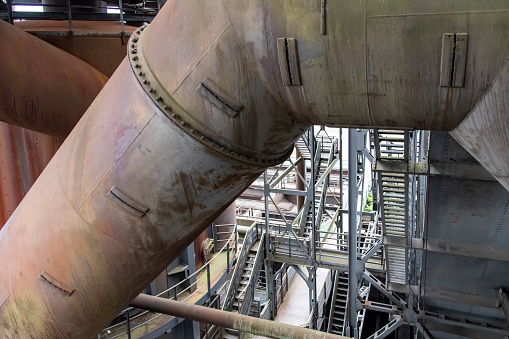 Duisburg, Landschaftspark, Germany-April 2022; View of the area with stairs, equipment and pipes of an abandoned blast furnace in an old ironworks factory