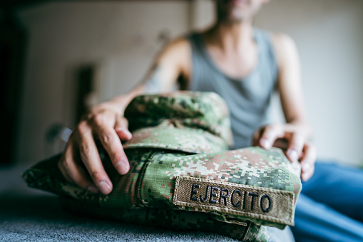 Close-up of a camouflage suit on the bed