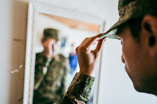 Close-up of an army soldier putting on cap