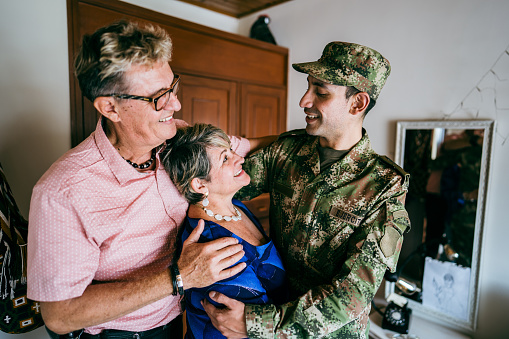 Soldier embracing parents at home