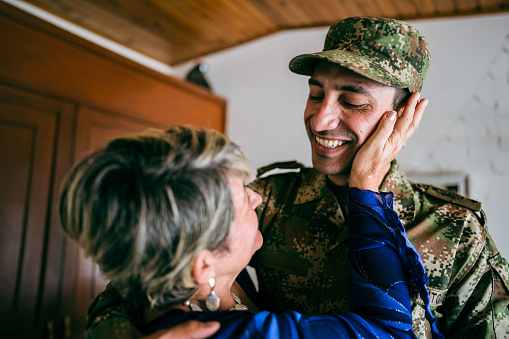 Soldier embracing his mother at home