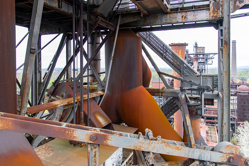 Duisburg, Landschaftspark, Germany-April 2022; High level view over the top of an abandoned blast furnace with equipment, pipes and steel construction in an old ironworks factory