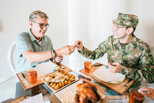 Soldier having lunch with his father at home