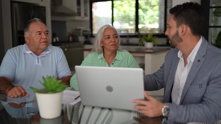 Financial advisor having a meeting with senior couple at home