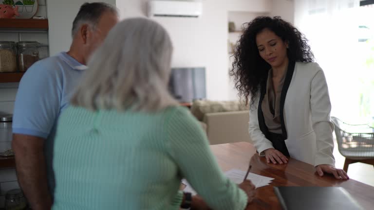 Senior couple on a meeting with financial advisor or real estate agent at a house