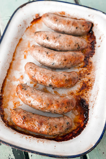 istock Cooked Sausages in old enamelware tray on painted wooden background 164493387