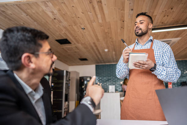 istock Mature man being served through waiter at office coffee shop 1644935004