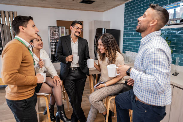 istock Happy coworkers talking while drinking coffee at office 1644938645