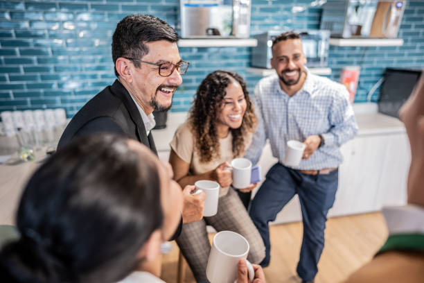 istock Happy coworkers talking while drinking coffee at office 1644938647