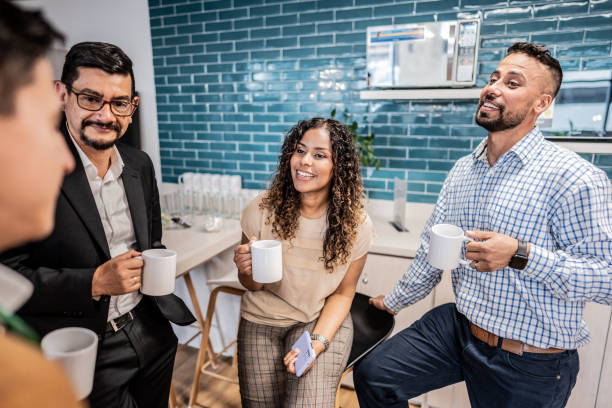 istock Happy coworkers talking while drinking coffee at office 1644938649