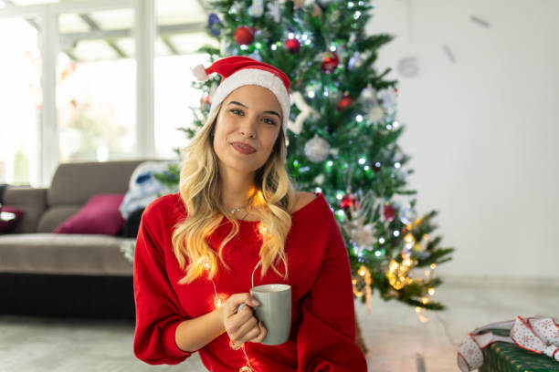 istock Beautiful woman decorating the Christmas tree 1644944592