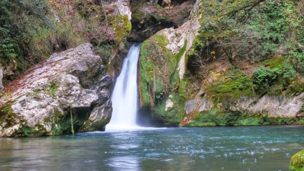 istock waterfall in the autumn forest. 1644948418