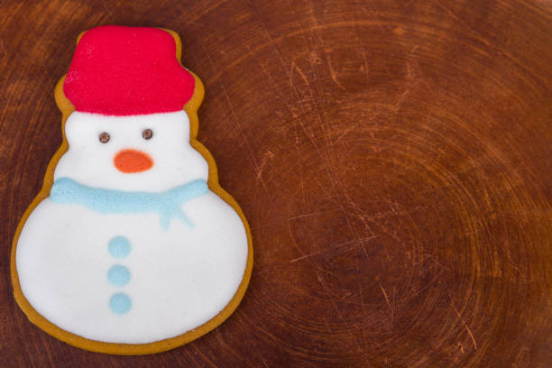Snowman cookie on wooden background with copy space. Top view.