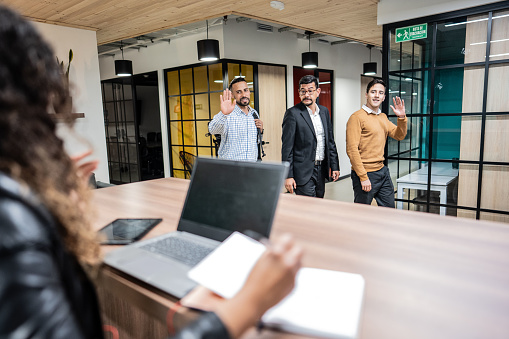 Business people arriving and greeting coworker at office reception