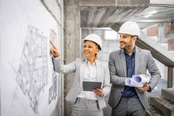 istock Civil engineers working together at construction site, controlling and inspecting building process. Looking at project plan and blueprint. 1644961738