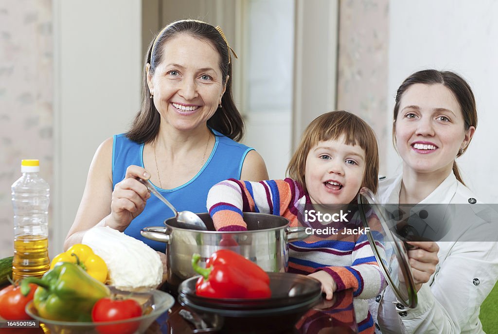 Donna matura e figlia adulta con ragazza cook pranzo - Foto stock royalty-free di 45-49 anni