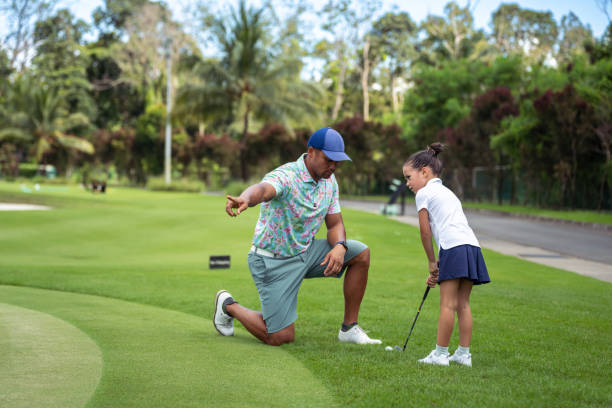 istock Young girl practices golf swing with the help of a professional 1645031380