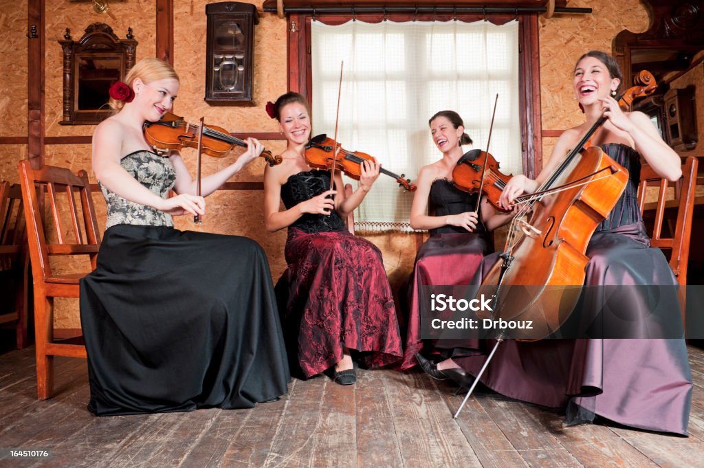 String quartet String quartet; Four beautiful young female musicians smiling while playing their instruments; Adobe RGB color space Cello Stock Photo