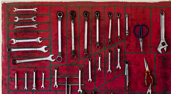 The metal mechanic tools on the red wall