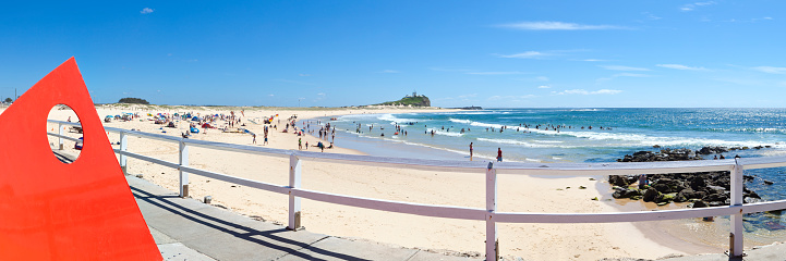 Wide angle panoramic image of Nobbys Beach in Newcastle during summer.