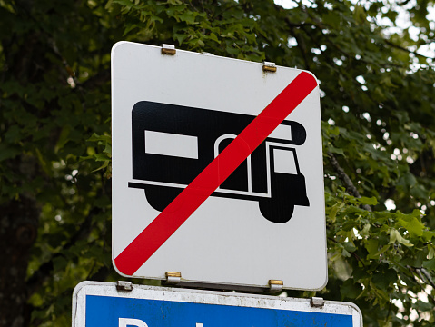 No camper van traffic sign at a parking lot in Austria. It is forbidden to park and to sleep in this area in a caravan.