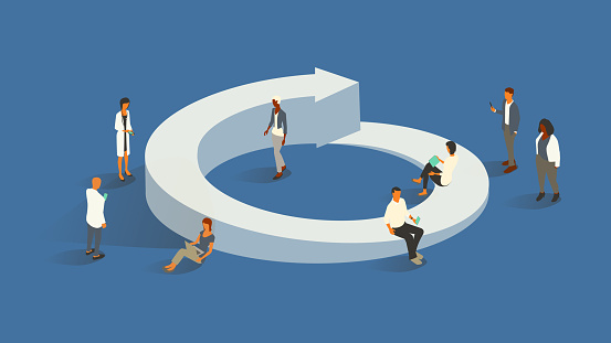 A group of 8 healthcare professionals gathers around an oversized, three-dimensional circular arrow icon to illustrate the concept of a healthcare-oriented life cycle. Diverse men and women use digital devices. Isometric vector presented in a 16x9 artboard, over a blue background.