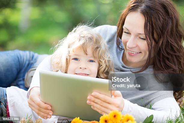 Photo libre de droit de Femme Et Enfants À Laide Dune Tablette Pc En Plein Air banque d'images et plus d'images libres de droit de Adulte