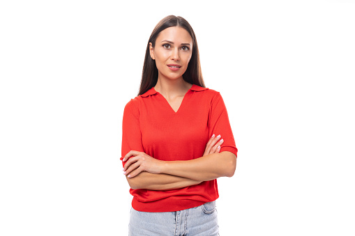 young charming european woman with black hair is dressed in a red t-shirt on a white background.