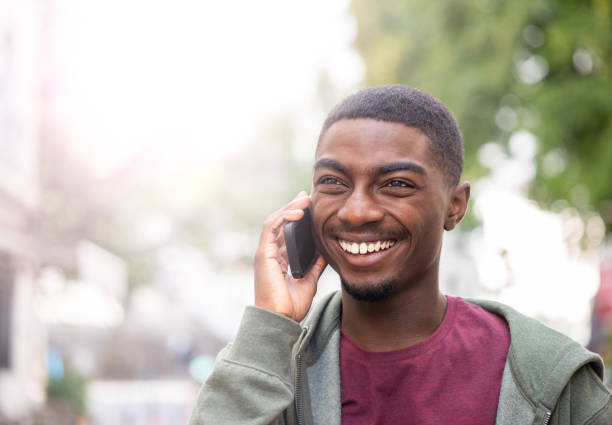 istock Close up smiling young african American man using cellphone outdoors 1645232997