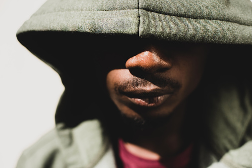 Close up portrait young African American man with hoodie covering face