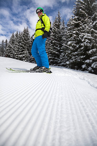 Skier on freshly groomed slope Male skier looking down the trail towards the camera corduroy jacket stock pictures, royalty-free photos & images