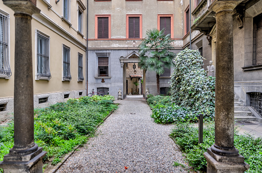 Milan, Italy - July 12, 2022: An ornate corridor leading to a courtyard on the streets of Milan