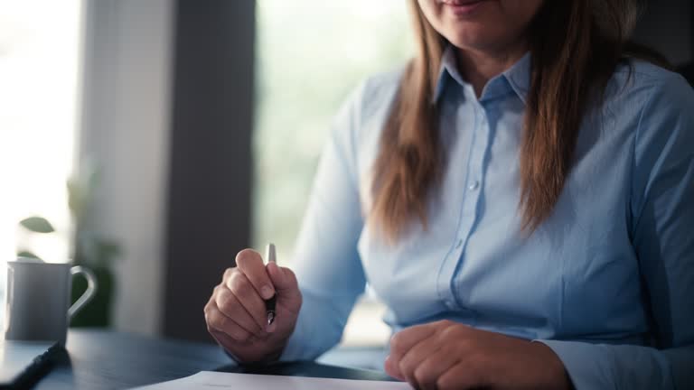 Businesswoman Signing Legal Paper In Office