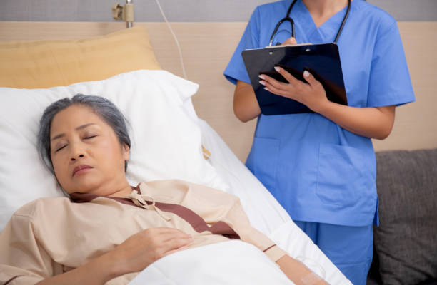 istock Asian nurse check saline and check patient elderly while asleep on bed at hospital ward, doctor diagnostic senior woman while sleep and writing report on clipboard, medical and insurance concept. 1645319008