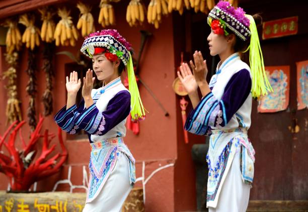 Minority women play an instrument in Yunnan's Ethnic Village Kunming, China-January 30, 2012: Minority women play an instrument in Yunnan's Ethnic Village yunnan province stock pictures, royalty-free photos & images