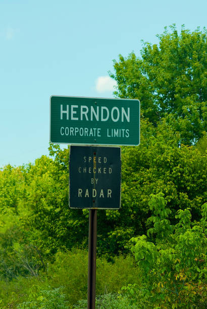 Corporate Limits, Herndom, Virginia (USA) Herndon, Virginia, USA - August 25, 2023: A metal sign indicates the “Corporate Limits” of the Town of Herndon and another sign warns drivers of speeding. herndon virginia stock pictures, royalty-free photos & images