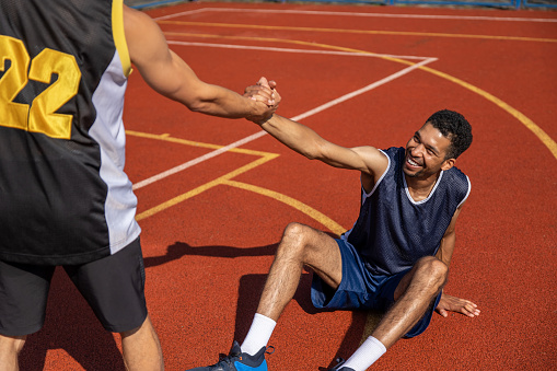 Basketball players on basketball court after playing intense match outdoor.