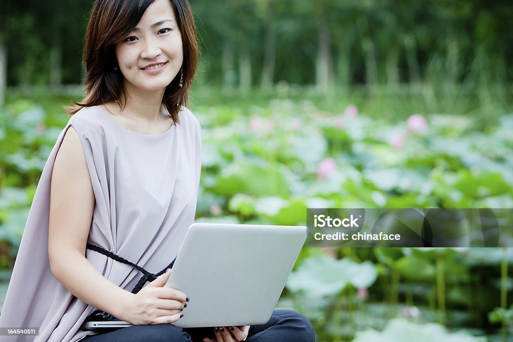 China Empresaria sonriente uso portátil - Foto de stock de 20 a 29 años libre de derechos