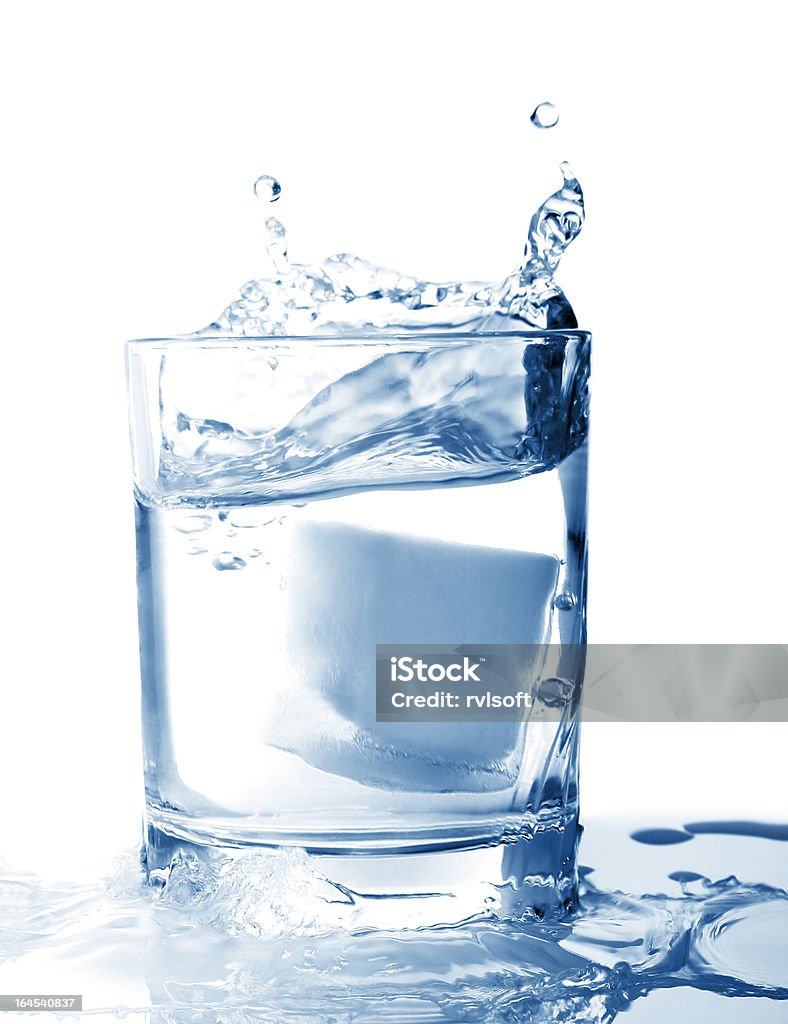 Ghiaccio in un bicchiere di acqua con splash - Foto stock royalty-free di Acqua