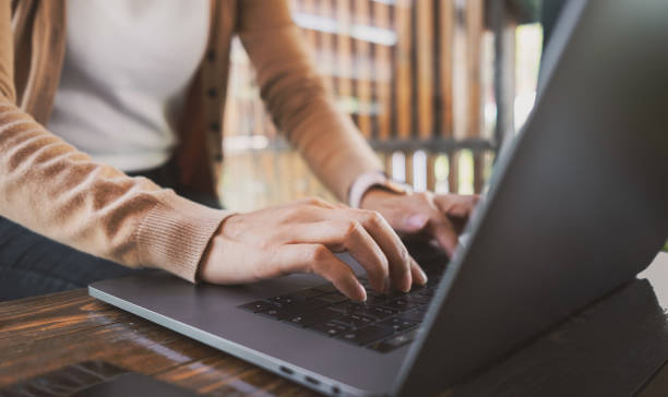 istock Female hands typing on laptop while sitting at office desk indoors. chatting in facebook, searching information, browsing. Technology concept 1645445201