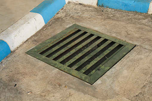iron sewer cover or gutter in a parking lot to absorb water and prevent flooding