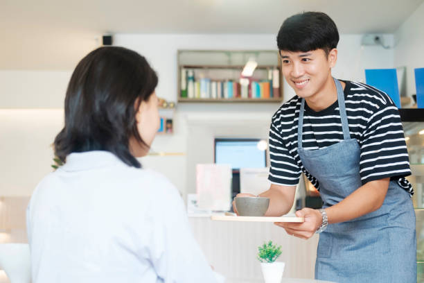 istock Waiter serving a cup of coffee to customer. 1645475441