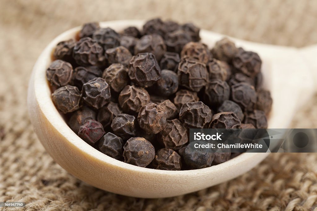 black pepper on wooden spoon black peppercorns on wooden spoon Black Color Stock Photo